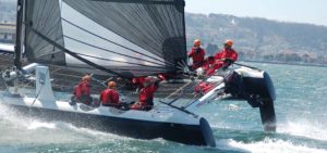People riding AC Sailing boat catamaran in ocean