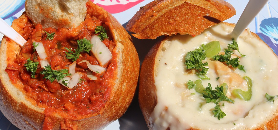Close up of red and white clam chowder in sourdough bread bowls