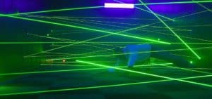 Man trying to navigate through a web of green lasers